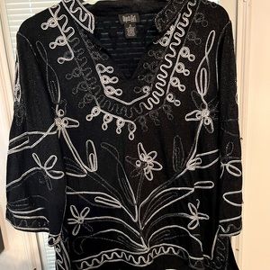 Black, sparkly material with embroidery design.